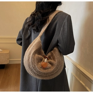 Détail d'un sac hobo en maille avec bouton en bois et empiècement en cuir marron chic