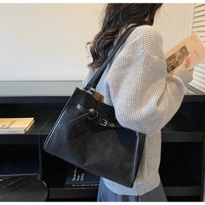 Détail du sac cabas noir mat avec boucle métallique argentée et grande bandoulière chic