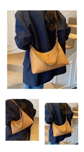 Vue détaillée du sac hobo en daim marron avec chaîne dorée et fermoir pivotant en métal