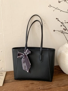 Elegant black lychee leather tote bag with a decorative silk scarf for modern women