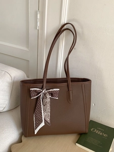 Brown leather tote bag with silk scarf and shoulder strap for elegant daily commuting