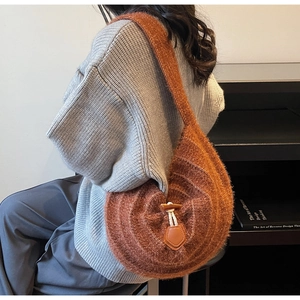 Détail du sac à bandoulière en maille marron avec boucle en corne rétro et rabat en cuir