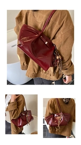 Detail of burgundy patent leather tote bag with glossy texture and star charm