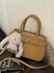 Borsa a tracolla giallo zenzero con cuciture bianche e ciondolo a forma di coniglio