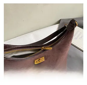 Vue détaillée du sac sous le bras en daim vintage avec fermoir doré et fermeture éclair