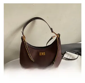 Vue détaillée du sac hobo en daim marron foncé avec fermoir doré et bandoulière en chaîne dorée