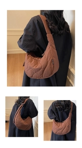 Detailed wave quilting and black brand tag on brown crescent crossbody bag