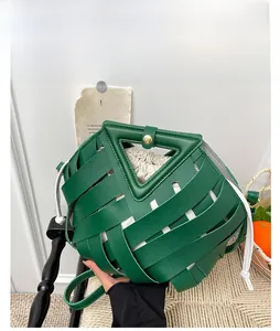 Dettaglio borsa a mano intrecciata verde a triangolo con strisce in pelle e sacchetto