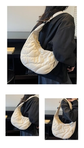 Detailed view of large white quilted crescent bag with wavy stitching and wide strap