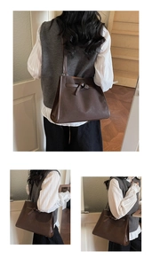 Detail view of large brown vintage tote bag with buckle knot and trapezoid structure