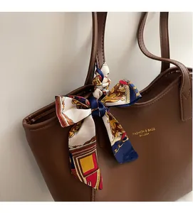 Detail of dark brown tote bag featuring luxury PU leather and a vintage silk scarf handle