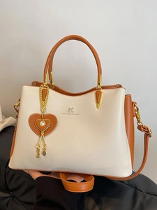 Sac à main élégant bicolore crème et marron avec logo kangourou doré et breloque cœur