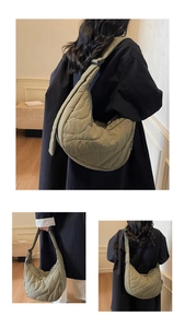 Detail of green wavy quilted crescent bag featuring adjustable strap and woven brand tag