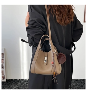 Detail of elephant gray lychee leather bucket bag with silver twist lock and charms