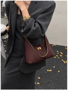 Gros plan du sac bandoulière en daim marron avec fermoir doré et chaîne vintage