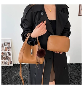 Brown leather bucket bag set with plush charm and matching small makeup pouch detail