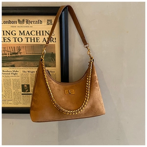 Détail du sac hobo en daim marron avec chaîne dorée et fermoir rotatif carré chic