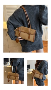 Detail of suede shoulder bag with leather trim and heart charm in caramel brown