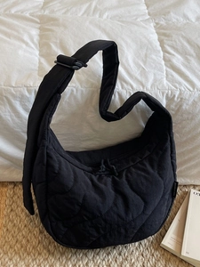 Black quilted crescent shoulder bag with adjustable strap for versatile daily commuting