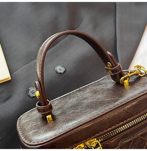 Détail du sac seau marron café vintage montrant la boucle dorée et le cuir synthétique
