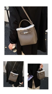 Detail of taupe pebbled leather bucket bag with white faux fur trim and metal twist lock