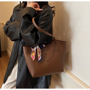 Brown leather tote bag featuring a decorative printed scarf and gold logo detail