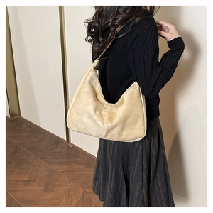 Detail of minimalist beige hobo bag with soft textured material and natural draping folds