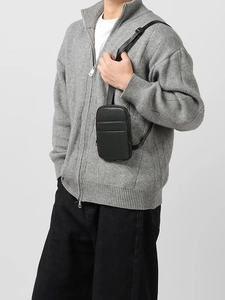 Minimalist black faux leather crossbody bag with lychee texture and adjustable strap