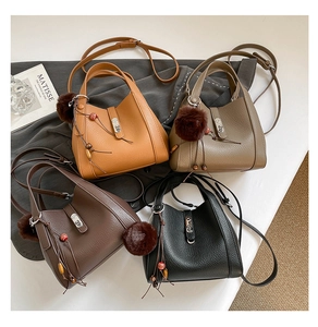 Detailed view of four colorful lychee pattern bucket bags with decorative charms
