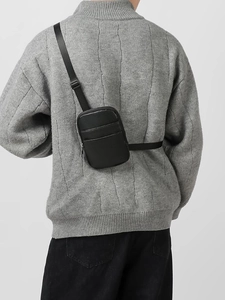 Women black crossbody phone bag with litchi texture and adjustable strap on a model
