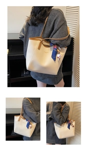 Detail of beige tote bag with brown handles and decorative blue printed silk scarf