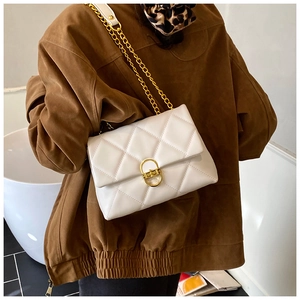 Detail of white quilted chain bag with gold twist lock and elegant leather strap