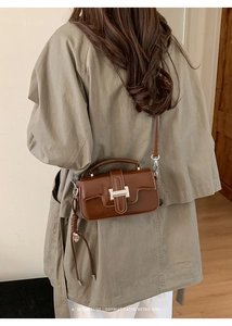Brown retro square handbag with metallic clasp shown on model for daily commuting