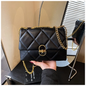 Detail of black quilted leather with gold oval clasp and metallic chain strap