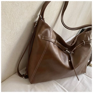 Détail du sac fourre-tout marron foncé en cuir ciré brillant avec coutures contrastées blanches