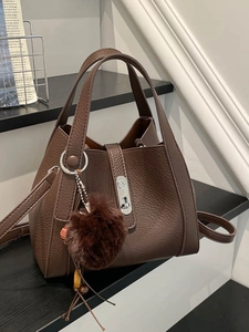 Brown litchi grain leather bucket bag with silver twist lock and faux fur ball charm