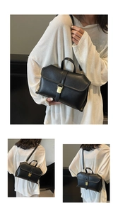 Detailansicht der schwarzen Lederhandtasche mit weißen Nähten und goldenem Verschluss