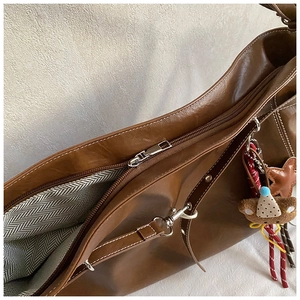 Gros plan du sac cabas marron avec fermeture éclair et doublure à motif chevrons