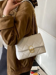 White quilted chain shoulder bag with gold hardware and classic flap design for women