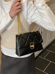 Elegant black quilted crossbody bag with gold chain strap and metal lock closure