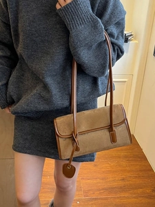 Chic brown suede patchwork underarm bag with slim leather straps on a model in a warm room