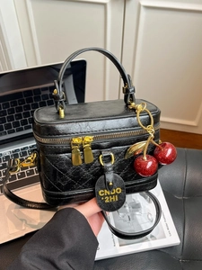 Petit sac vintage en cuir noir matelassé avec dorure et pendentif cerise rouge chic