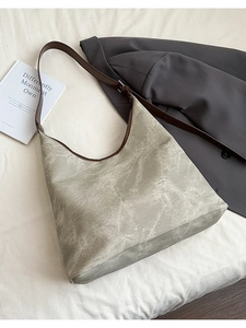 Detail of grey textured tote bag with brown adjustable strap and spacious interior