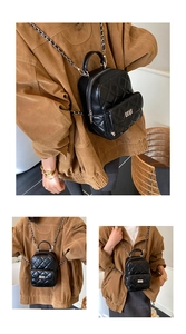 Detail view of black quilted mini backpack with metal chain strap and turn-lock pocket