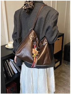 Sac cabas marron avec coutures contrastées et breloque ours dans un style de vie urbain