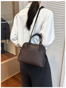 Detail view of dark brown lychee texture shell bag with adjustable thin leather strap