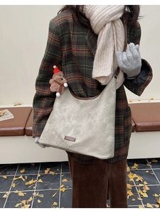 Detailed view of cream retro tote bag with brown trim and festive bear charm