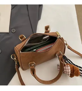 Top view of brown Boston bag interior showing spacious capacity with a cute bear charm