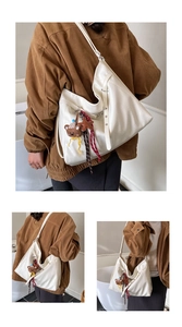 Detail view of large white Hobo tote bag featuring a cute brown bear charm and soft PU leather