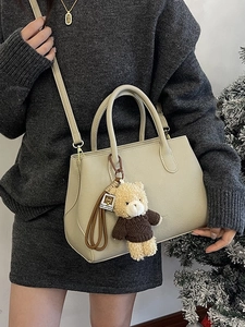 Elegante borsa a secchiello beige con ciondolo a orsetto per la moda invernale